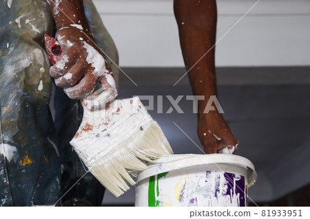 a paint worker with brush on hand and paint 81933951