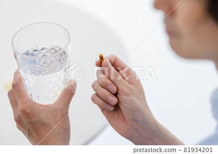 Men trying to drink capsules with water 81934201