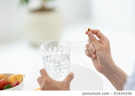 Men trying to drink capsules with water 81934206