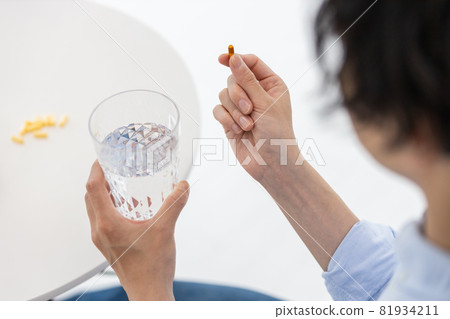 Men trying to drink capsules with water 81934211