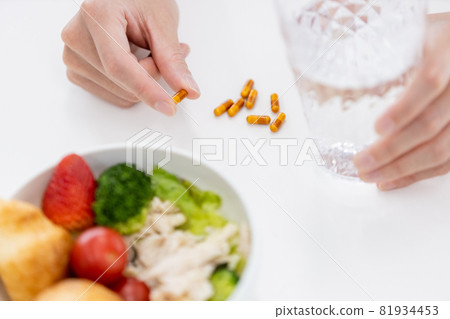 Hands of a man trying to take a capsule 81934453
