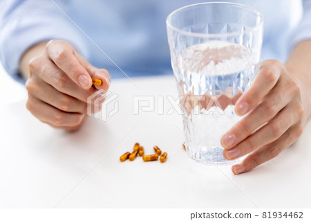 Hands of a man trying to take a capsule Hands of a man trying to take a capsule 81934462