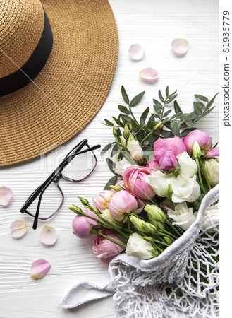 Straw hat and  bouquet of pink rose flowers on white background. 81935779