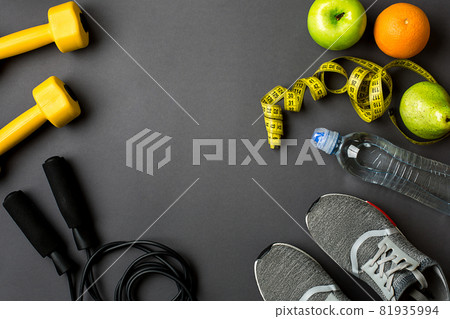 Workout plan with fitness food and equipment on gray background, top view Workout plan with fitness food and equipment on gray background, top view 81935994