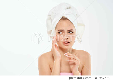 woman holding face with towel on head clean skin dermatology 81937580