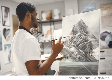 Young African-American artist painting picture in workshop 81938086