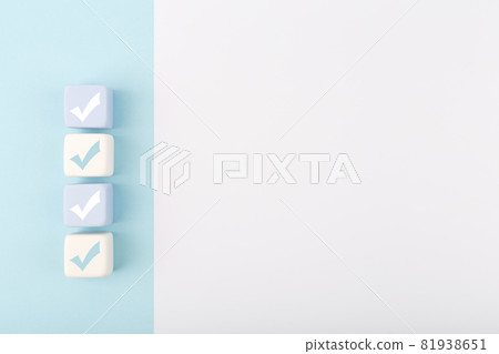 Checkmarks on four light toy blocks against white background with copy space 81938651