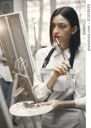 Female artist paints picture on canvas with oil paints 81938689