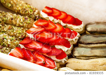 Gastronomic box with sweet eclairs with cheese mousse and fresh berries, chocolate-coated cream, pistachio crumbs. Snacks for catering buffet Gastronomic box with sweet eclairs with cheese mousse and fresh berries, chocolate-coated cream, pistachio crumbs. Snacks for catering buffet 81939335