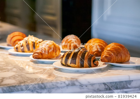 Several croissants are placed on the marble table before serving. Several croissants are placed on the marble table before serving. 81939424