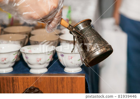 Copper cezve with Turkish coffee pouring out. Oriental, east coffee. Copper cezve with Turkish coffee pouring out. Oriental, east coffee. 81939446