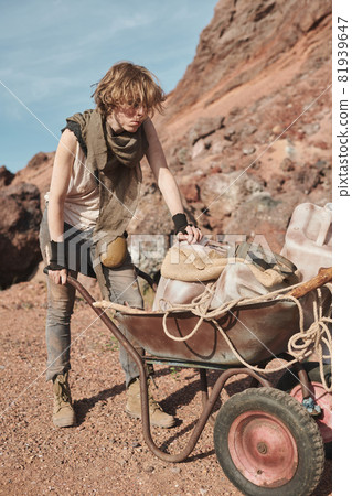 Young woman with cart in the desert Young woman with cart in the desert 81939647