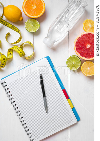 Healthy breakfast with fresh fruits and bottle of water with notebook on rustic wooden table. Healthy breakfast with fresh fruits and bottle of water with notebook on rustic wooden table. 81941976