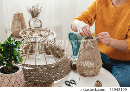 Woman makes handmade diy lamp from jute rope 81942199