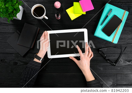 Hand use tablet on desk table top view Hand use tablet on desk table top view 81942203