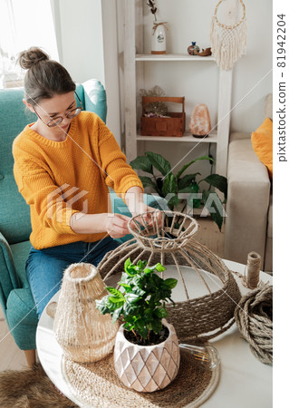 Woman makes handmade diy lamp from jute rope Woman makes handmade diy lamp from jute rope 81942204