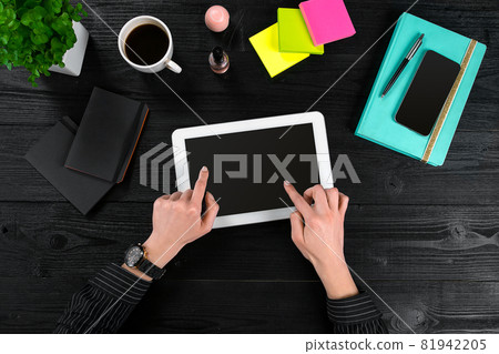 Mix of office supplies and gadgets on a wooden desk background. View from above. Mix of office supplies and gadgets on a wooden desk background. View from above. 81942205