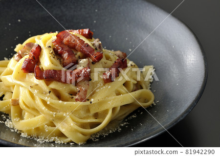 Crispy baked fettuccine carbonara with bacon shot on a black background Crispy baked fettuccine carbonara with bacon shot on a black background 81942290