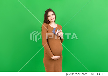 Happy pregnant woman showing small boots for a baby boy at Colored background. Future mother is waiting for a child. Copy space 81943116