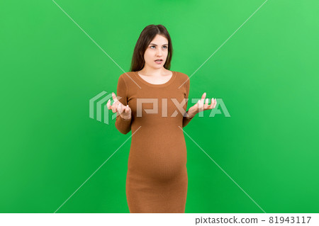 Young beautiful teenager girl pregnant expecting baby over isolated colored background, aggressive expression and arms raised. Frustration concept 81943117