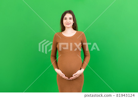 Happy pregnant woman touching her abdomen at Colored background. Future mother is wearing white underwear. Expecting of a baby. Copy space Happy pregnant woman touching her abdomen at Colored background. Future mother is wearing white underwear. Expecting of a baby. Copy space 81943124