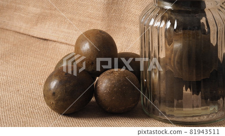 Monk fruit or Luo Han Guo. Dried fruits for healthy sweetener drink. Natural herbal remedy and glass bottle background. Monk fruit drink for who concern health and sugar substitute. Monk fruit or Luo Han Guo. Dried fruits for healthy sweetener drink. Natural herbal remedy and glass bottle background. Monk fruit drink for who concern health and sugar substitute. 81943511
