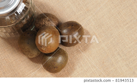 Monk fruit or Luo Han Guo. Dried fruits for healthy sweetener drink. Natural herbal remedy and glass bottle background. Monk fruit drink for who concern health and sugar substitute. 81943513