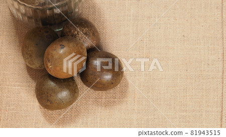 Monk fruit or Luo Han Guo. Dried fruits for healthy sweetener drink. Natural herbal remedy and glass bottle background. Monk fruit drink for who concern health and sugar substitute. 81943515