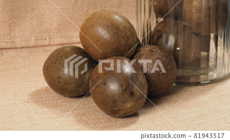 Monk fruit or Luo Han Guo. Dried fruits for healthy sweetener drink. Natural herbal remedy and glass bottle background. Monk fruit drink for who concern health and sugar substitute. 81943517