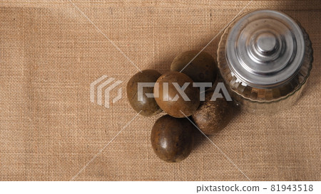 Monk fruit or Luo Han Guo. Dried fruits for healthy sweetener drink. Natural herbal remedy and glass bottle background. Monk fruit drink for who concern health and sugar substitute. 81943518