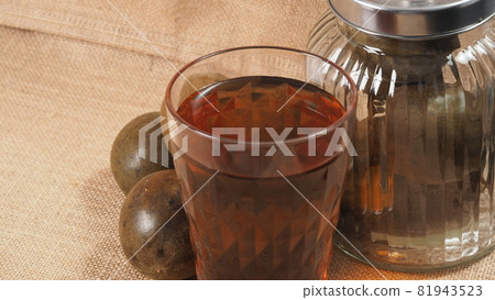 Monk fruit or Luo Han Guo. Dried fruits for healthy sweetener drink. Natural herbal remedy and glass bottle background. Monk fruit drink for who concern health and sugar substitute. Monk fruit or Luo Han Guo. Dried fruits for healthy sweetener drink. Natural herbal remedy and glass bottle background. Monk fruit drink for who concern health and sugar substitute. 81943523