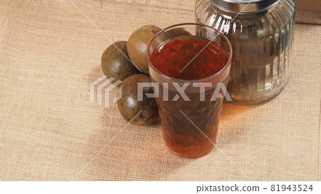 Monk fruit or Luo Han Guo. Dried fruits for healthy sweetener drink. Natural herbal remedy and glass bottle background. Monk fruit drink for who concern health and sugar substitute. 81943524