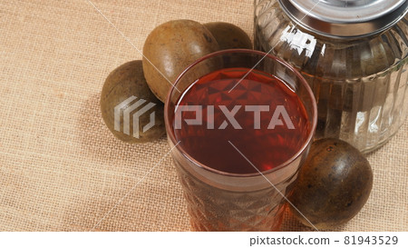 Monk fruit or Luo Han Guo. Dried fruits for healthy sweetener drink. Natural herbal remedy and glass bottle background. Monk fruit drink for who concern health and sugar substitute. Monk fruit or Luo Han Guo. Dried fruits for healthy sweetener drink. Natural herbal remedy and glass bottle background. Monk fruit drink for who concern health and sugar substitute. 81943529