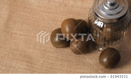 Monk fruit or Luo Han Guo. Dried fruits for healthy sweetener drink. Natural herbal remedy and glass bottle background. Monk fruit drink for who concern health and sugar substitute. Monk fruit or Luo Han Guo. Dried fruits for healthy sweetener drink. Natural herbal remedy and glass bottle background. Monk fruit drink for who concern health and sugar substitute. 81943531