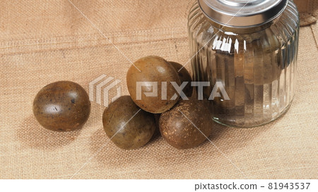 Monk fruit or Luo Han Guo. Dried fruits for healthy sweetener drink. Natural herbal remedy and glass bottle background. Monk fruit drink for who concern health and sugar substitute. Monk fruit or Luo Han Guo. Dried fruits for healthy sweetener drink. Natural herbal remedy and glass bottle background. Monk fruit drink for who concern health and sugar substitute. 81943537