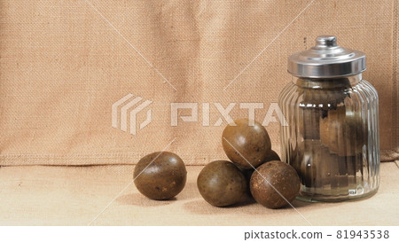 Monk fruit or Luo Han Guo. Dried fruits for healthy sweetener drink. Natural herbal remedy and glass bottle background. Monk fruit drink for who concern health and sugar substitute. Monk fruit or Luo Han Guo. Dried fruits for healthy sweetener drink. Natural herbal remedy and glass bottle background. Monk fruit drink for who concern health and sugar substitute. 81943538