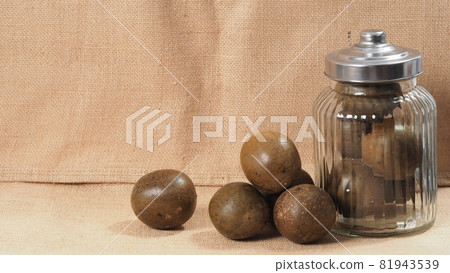 Monk fruit or Luo Han Guo. Dried fruits for healthy sweetener drink. Natural herbal remedy and glass bottle background. Monk fruit drink for who concern health and sugar substitute. 81943539