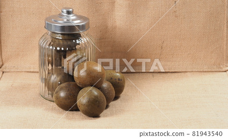 Monk fruit or Luo Han Guo. Dried fruits for healthy sweetener drink. Natural herbal remedy and glass bottle background. Monk fruit drink for who concern health and sugar substitute. 81943540