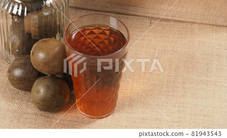 Monk fruit or Luo Han Guo. Dried fruits for healthy sweetener drink. Natural herbal remedy and glass bottle background. Monk fruit drink for who concern health and sugar substitute. Monk fruit or Luo Han Guo. Dried fruits for healthy sweetener drink. Natural herbal remedy and glass bottle background. Monk fruit drink for who concern health and sugar substitute. 81943543