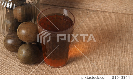 Monk fruit or Luo Han Guo. Dried fruits for healthy sweetener drink. Natural herbal remedy and glass bottle background. Monk fruit drink for who concern health and sugar substitute. 81943544