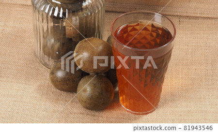 Monk fruit or Luo Han Guo. Dried fruits for healthy sweetener drink. Natural herbal remedy and glass bottle background. Monk fruit drink for who concern health and sugar substitute. Monk fruit or Luo Han Guo. Dried fruits for healthy sweetener drink. Natural herbal remedy and glass bottle background. Monk fruit drink for who concern health and sugar substitute. 81943546