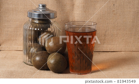 Monk fruit or Luo Han Guo. Dried fruits for healthy sweetener drink. Natural herbal remedy and glass bottle background. Monk fruit drink for who concern health and sugar substitute. Monk fruit or Luo Han Guo. Dried fruits for healthy sweetener drink. Natural herbal remedy and glass bottle background. Monk fruit drink for who concern health and sugar substitute. 81943549
