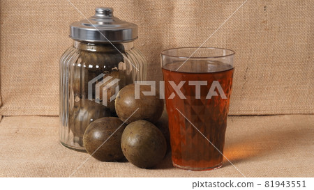 Monk fruit or Luo Han Guo. Dried fruits for healthy sweetener drink. Natural herbal remedy and glass bottle background. Monk fruit drink for who concern health and sugar substitute. 81943551