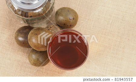 Monk fruit or Luo Han Guo. Dried fruits for healthy sweetener drink. Natural herbal remedy and glass bottle background. Monk fruit drink for who concern health and sugar substitute. Monk fruit or Luo Han Guo. Dried fruits for healthy sweetener drink. Natural herbal remedy and glass bottle background. Monk fruit drink for who concern health and sugar substitute. 81943557