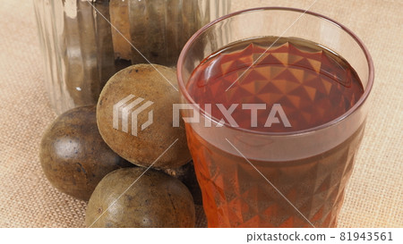 Monk fruit or Luo Han Guo. Dried fruits for healthy sweetener drink. Natural herbal remedy and glass bottle background. Monk fruit drink for who concern health and sugar substitute. Monk fruit or Luo Han Guo. Dried fruits for healthy sweetener drink. Natural herbal remedy and glass bottle background. Monk fruit drink for who concern health and sugar substitute. 81943561