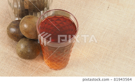 Monk fruit or Luo Han Guo. Dried fruits for healthy sweetener drink. Natural herbal remedy and glass bottle background. Monk fruit drink for who concern health and sugar substitute. 81943564