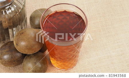 Monk fruit or Luo Han Guo. Dried fruits for healthy sweetener drink. Natural herbal remedy and glass bottle background. Monk fruit drink for who concern health and sugar substitute. 81943568