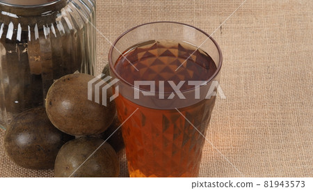 Monk fruit or Luo Han Guo. Dried fruits for healthy sweetener drink. Natural herbal remedy and glass bottle background. Monk fruit drink for who concern health and sugar substitute. 81943573