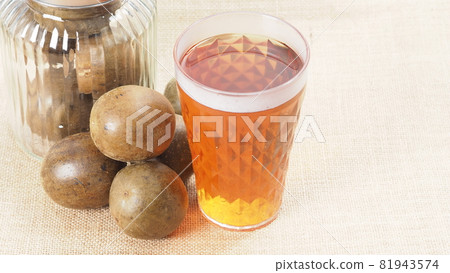 Monk fruit or Luo Han Guo. Dried fruits for healthy sweetener drink. Natural herbal remedy and glass bottle background. Monk fruit drink for who concern health and sugar substitute. Monk fruit or Luo Han Guo. Dried fruits for healthy sweetener drink. Natural herbal remedy and glass bottle background. Monk fruit drink for who concern health and sugar substitute. 81943574