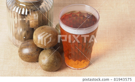 Monk fruit or Luo Han Guo. Dried fruits for healthy sweetener drink. Natural herbal remedy and glass bottle background. Monk fruit drink for who concern health and sugar substitute. 81943575